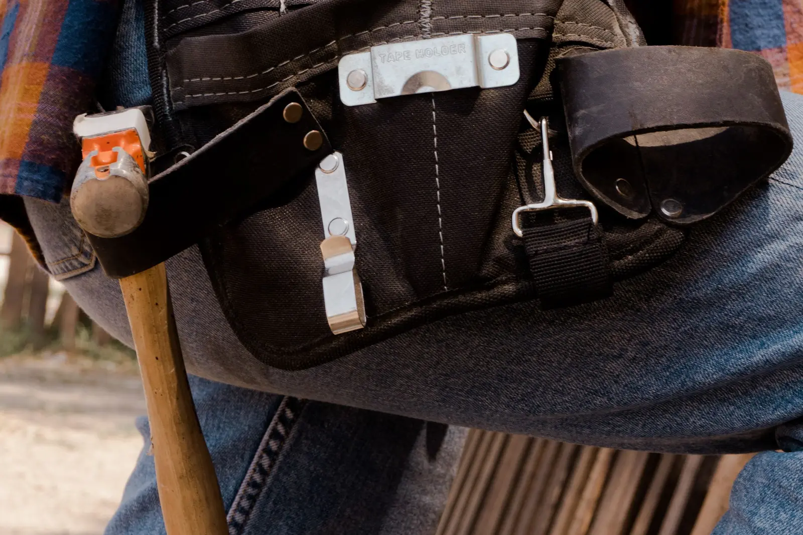 Leather tool belt with a hammer and tools worn by a handyman